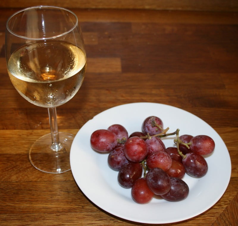 Ett glas vin och en portion vindruvor på helgdagsaftonen