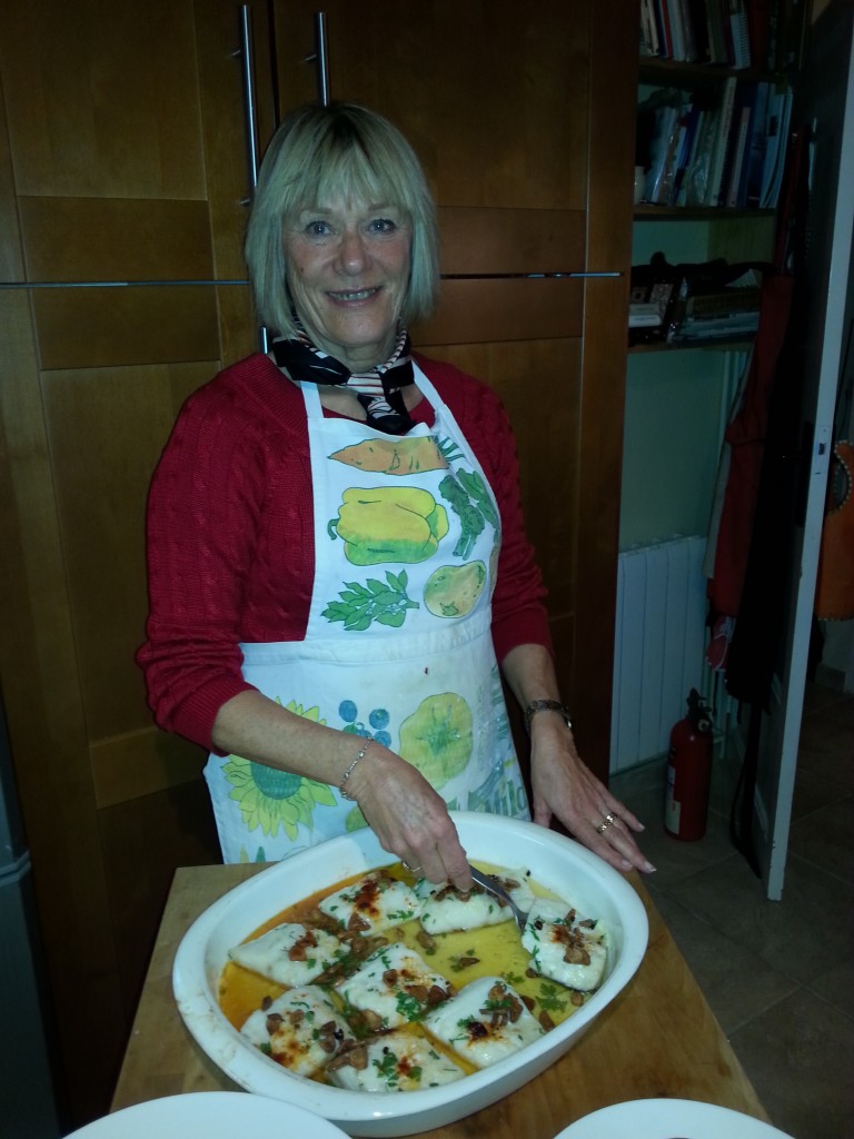 En stolt kökschef poserar med huvudrätten - Bacalao a la llauna